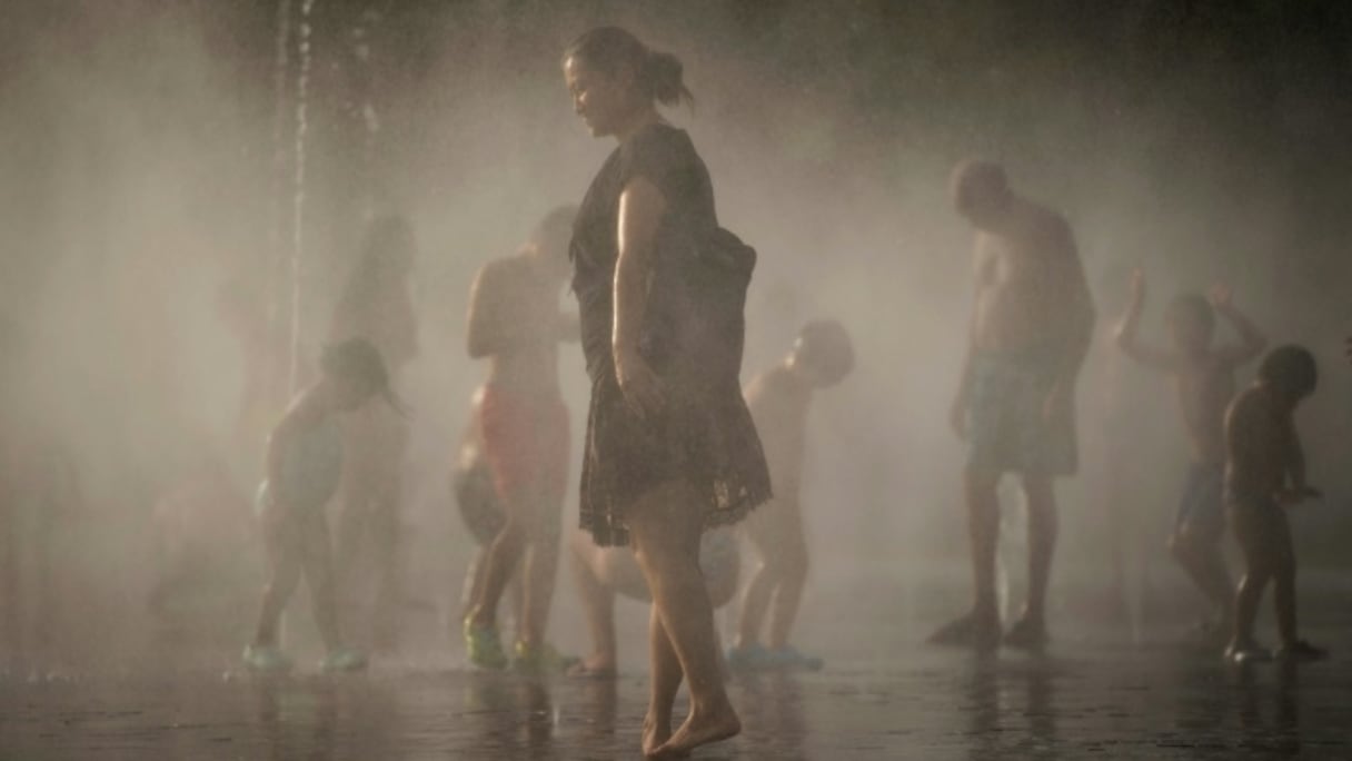 Des gens se rafraîchissent dans une fontaine de Madrid le 3 août 2018.